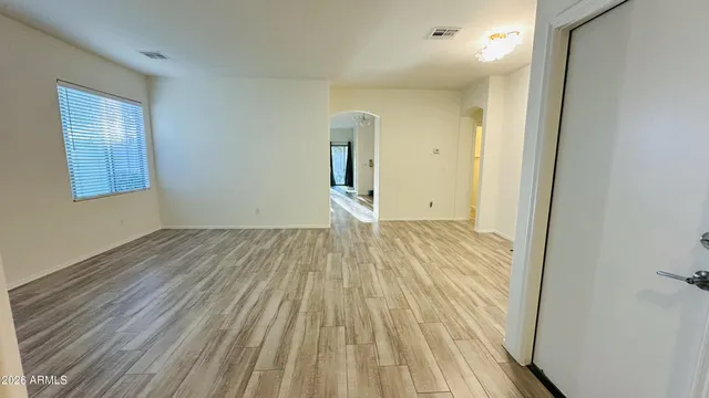 a view of a room with wooden floor white walls and entryway