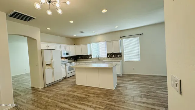 a kitchen with kitchen island white cabinets and stainless steel appliances