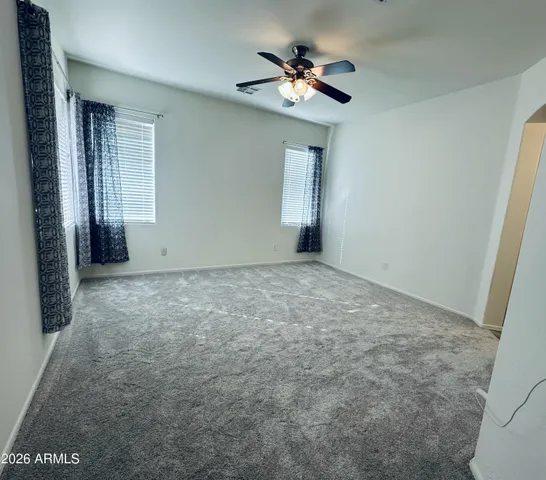 an empty room with windows and fan