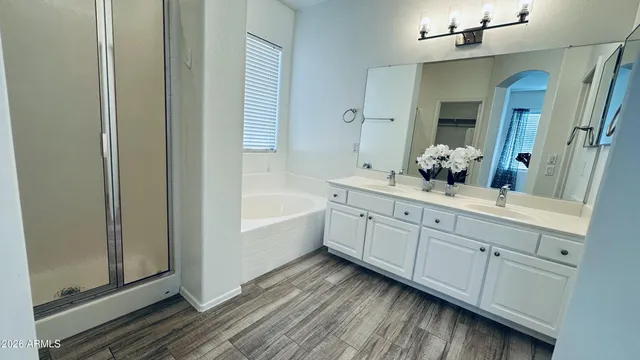 a bathroom with a tub sink and mirror