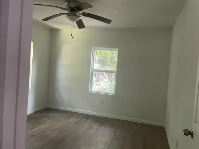 an empty room with a window and a fan