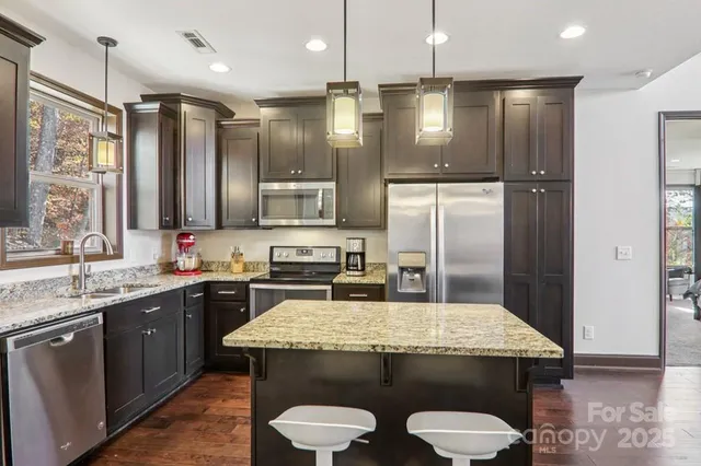 a kitchen with kitchen island a sink stove and refrigerator