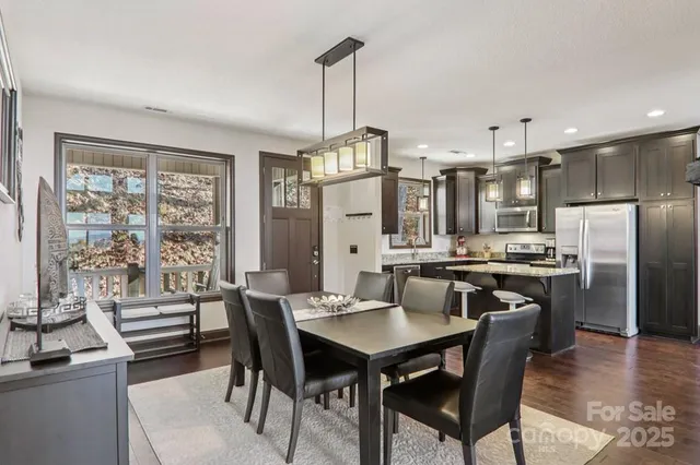 a view of a dining room and livingroom with furniture wooden floor a chandelier