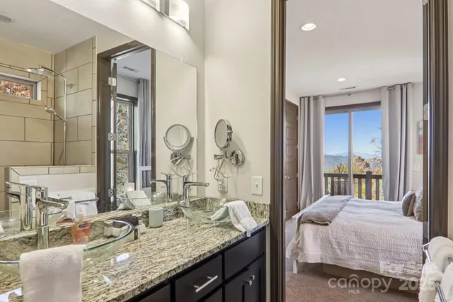 a en suite bathroom with a granite countertop sink and a mirror
