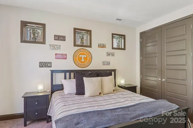 a bedroom with a bed and painting on the wall