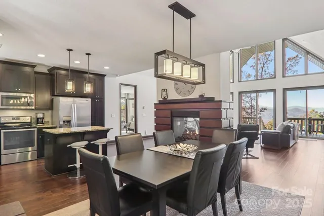 a view of a dining room and livingroom with furniture wooden floor a chandelier