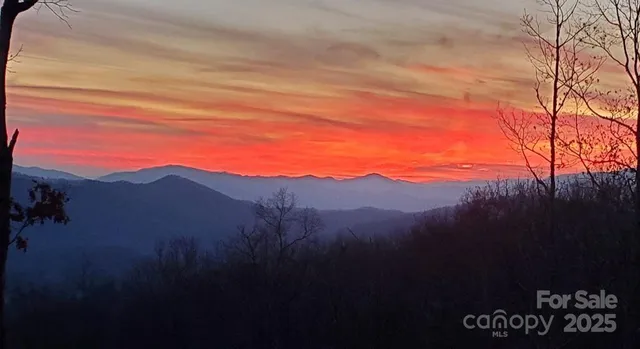 a view of mountain with sunset in background