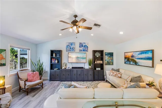 a living room with furniture ceiling fan and a window