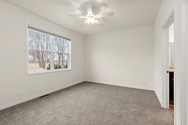 an empty room with windows and ceiling fan