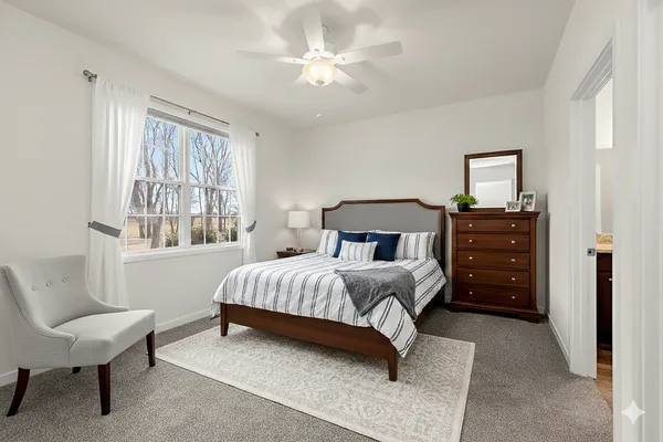 a bedroom with a bed a chandelier and a couch