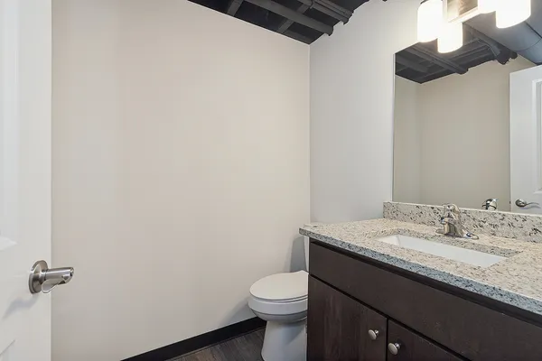 a bathroom with a granite countertop toilet and a sink