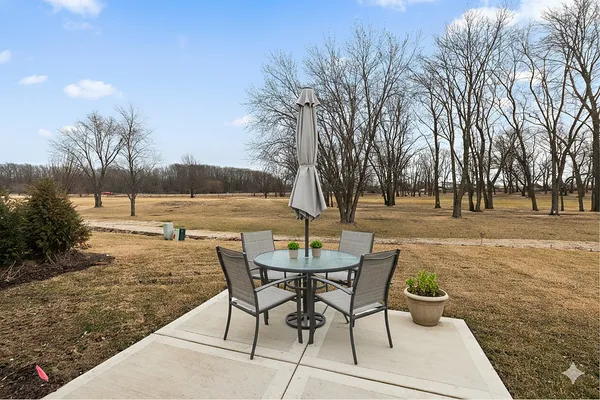 a view of a backyard with table and chairs under an umbrella