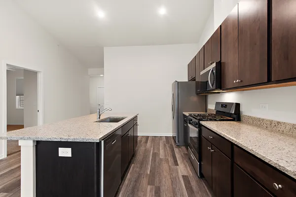 a kitchen with a sink dishwasher a stove and a refrigerator with wooden floor