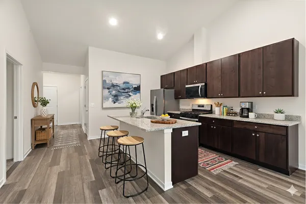 a kitchen with stainless steel appliances granite countertop wooden cabinets a stove top oven a sink and dishwasher