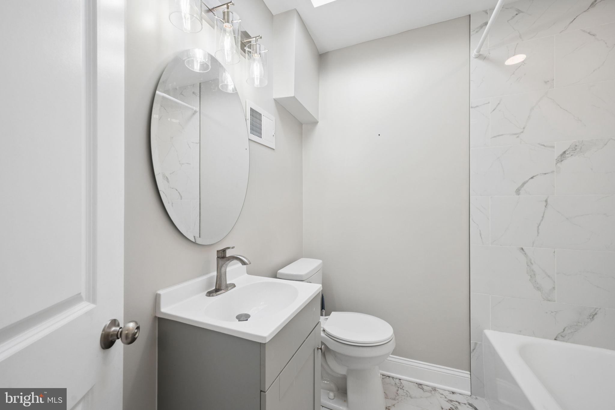 3548 Benzinger Road Baltimore, MD 21229 - Photo 19 of 40 a bathroom with a sink a toilet and a mirror