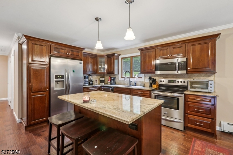 179 Mudtown Road Wantage, NJ 07461 - Photo 11 of 39 a kitchen with stainless steel appliances granite countertop a sink a stove a refrigerator cabinets and a dining table
