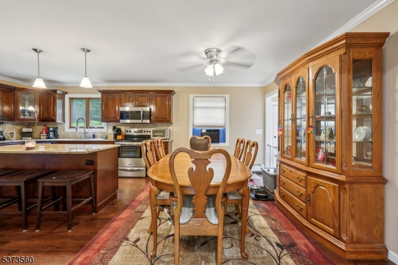 179 Mudtown Road Wantage, NJ 07461 - Photo 10 of 39 a kitchen with stainless steel appliances granite countertop a stove top oven a sink a dining table and chairs with wooden floor
