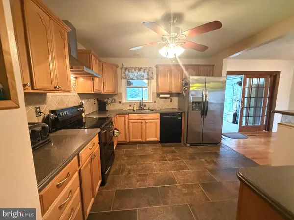 a kitchen with stainless steel appliances granite countertop a sink a stove and a refrigerator