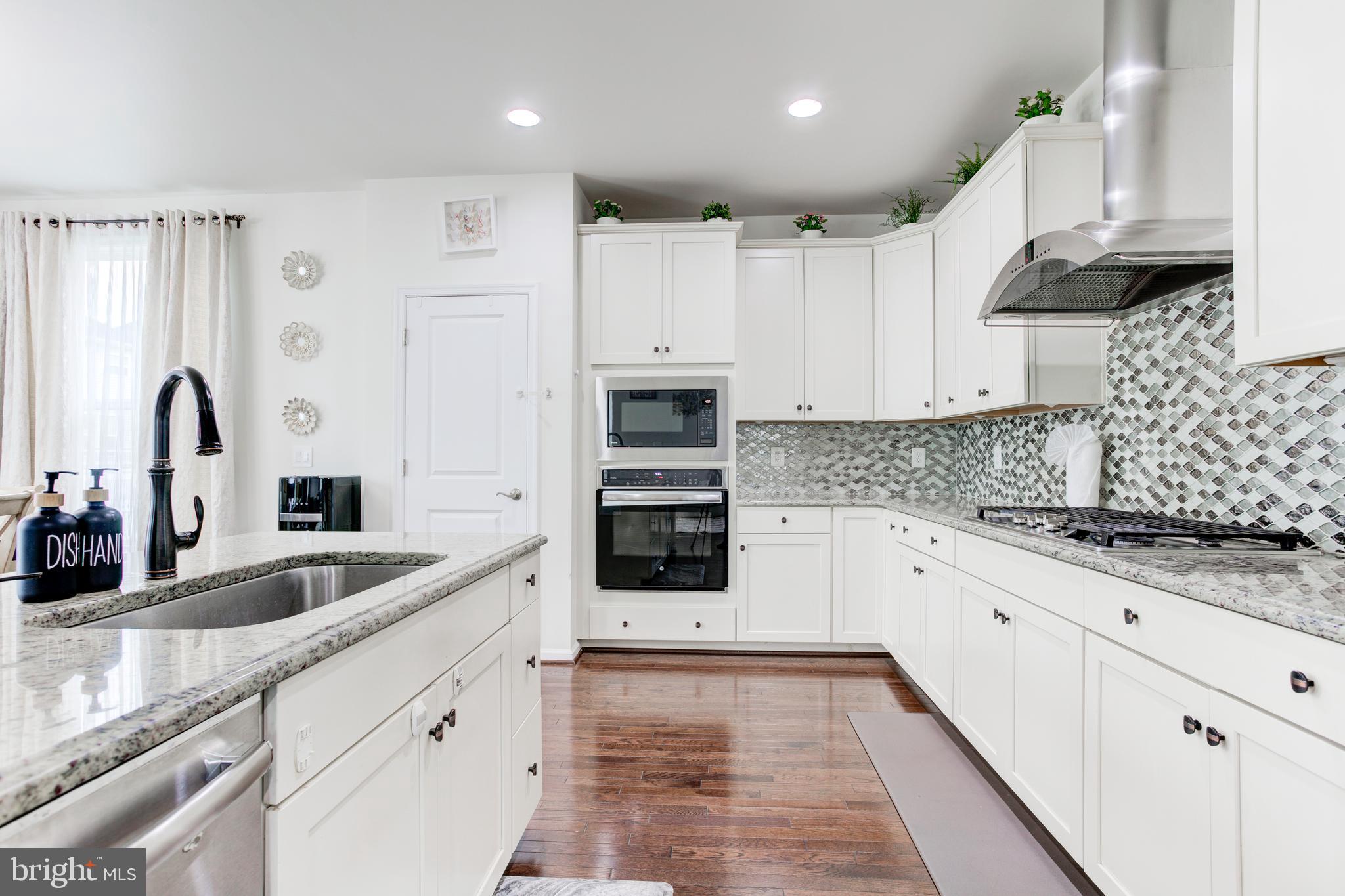 22800 Bubbling Brook Drive Brambleton, VA 20148 - Photo 25 of 64 a kitchen with granite countertop a sink stainless steel appliances and cabinets