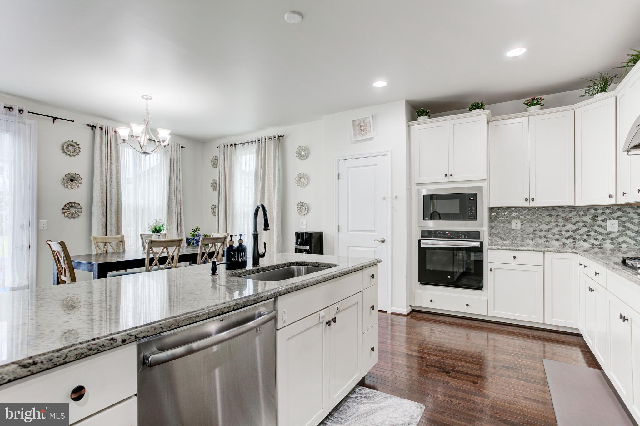 22800 Bubbling Brook Drive Brambleton, VA 20148 - Photo 26 of 64 a kitchen with stainless steel appliances a sink stove and cabinets