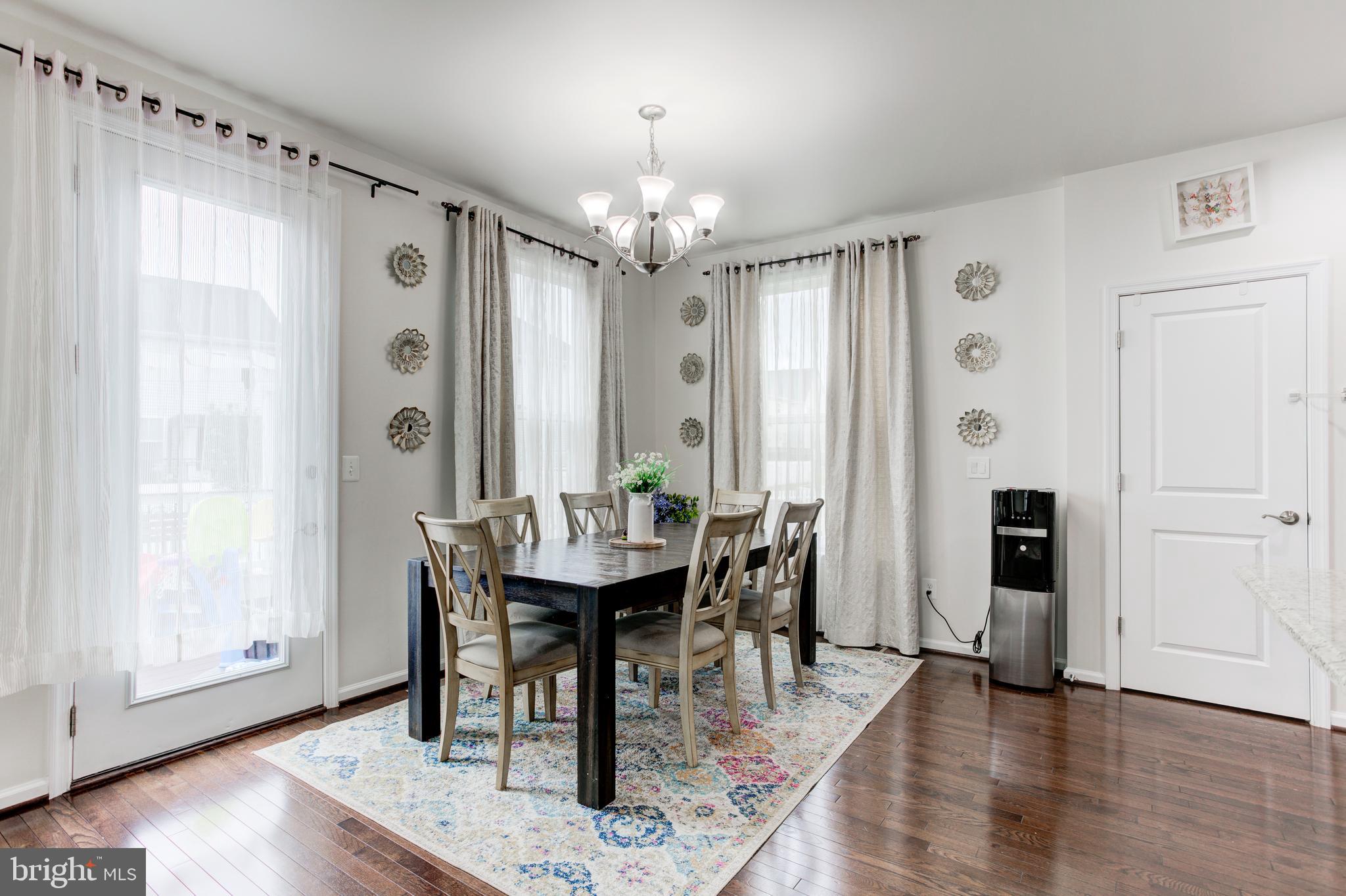 22800 Bubbling Brook Drive Brambleton, VA 20148 - Photo 27 of 64 a view of a a dining room with furniture window and wooden floor