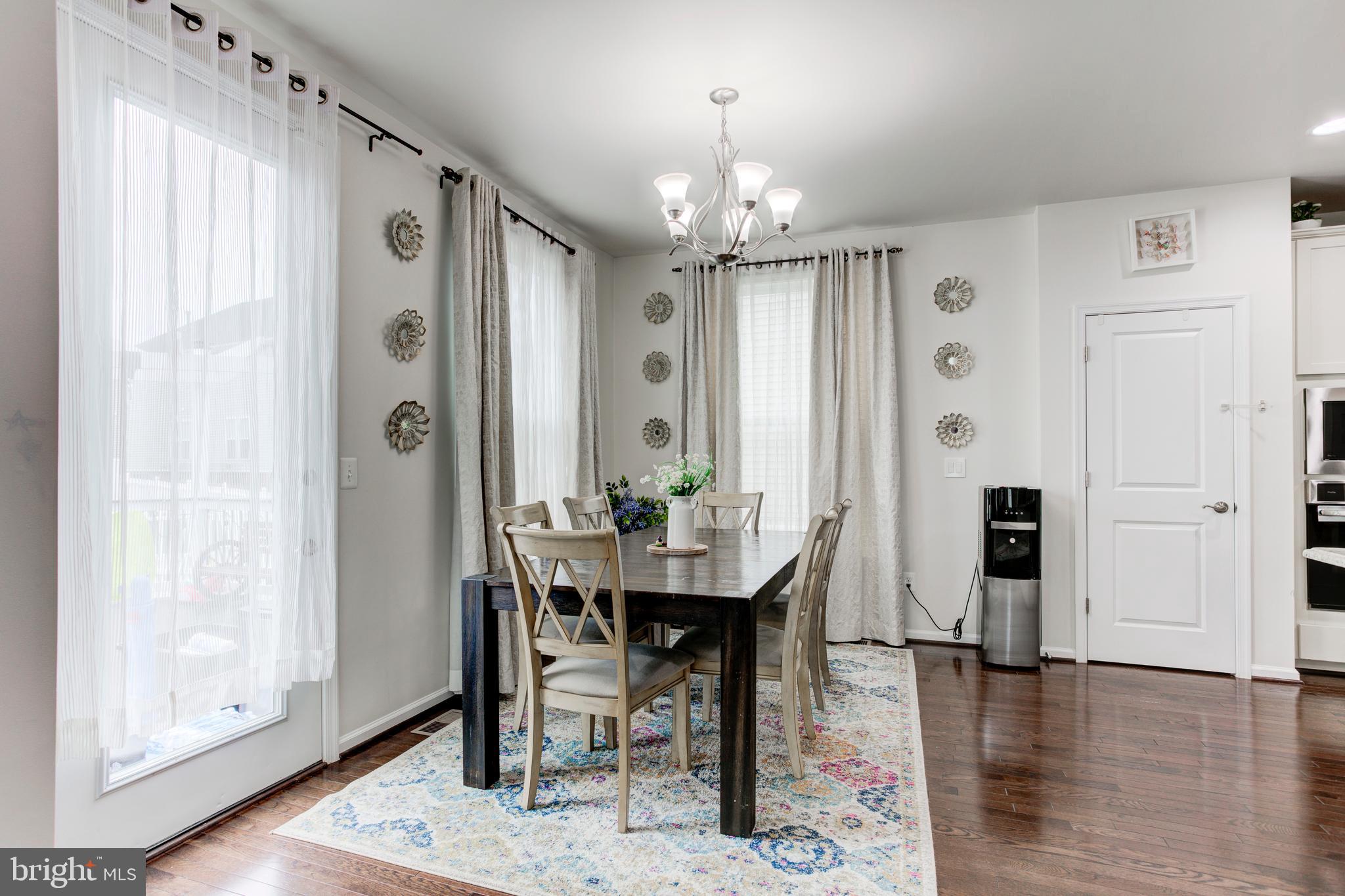22800 Bubbling Brook Drive Brambleton, VA 20148 - Photo 28 of 64 a view of a dining room with furniture and wooden floor