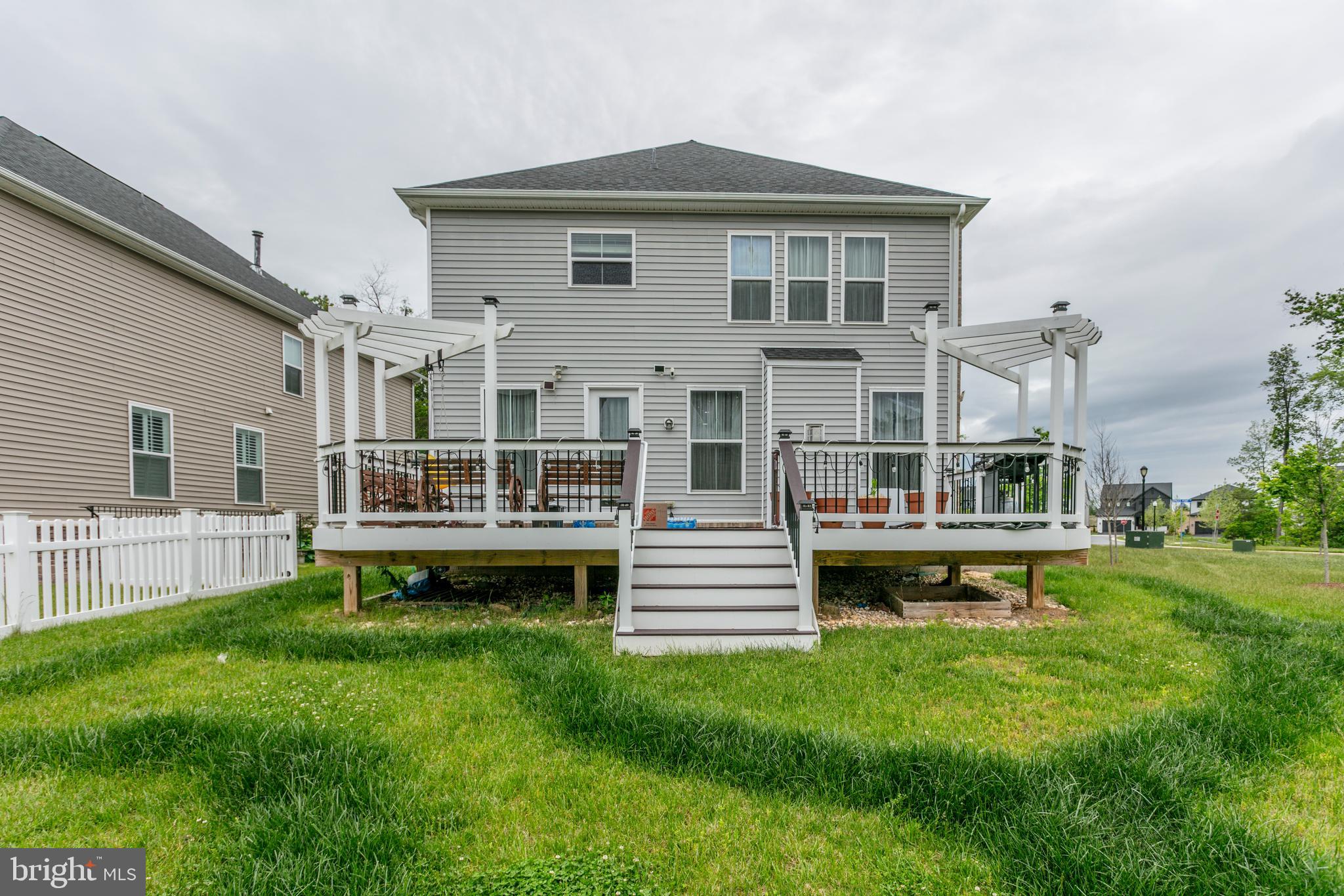 22800 Bubbling Brook Drive Brambleton, VA 20148 - Photo 63 of 64 a front view of a house with a garden and deck