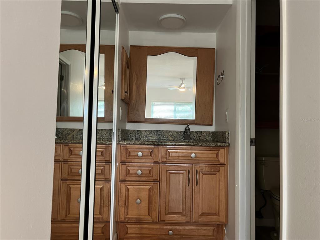 3160 Highlands Boulevard, Unit 3160 Palm Harbor, FL 34684 - Photo 11 of 40 a bathroom with a granite countertop sink and a mirror