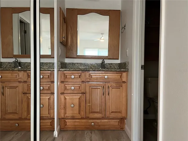 a bathroom with a granite countertop sink a vanity and a mirror