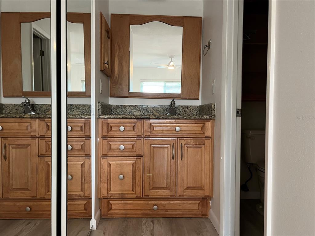 3160 Highlands Boulevard, Unit 3160 Palm Harbor, FL 34684 - Photo 13 of 40 a bathroom with a granite countertop sink a vanity and a mirror