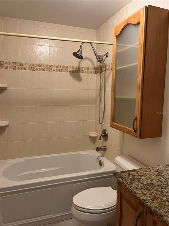 3160 Highlands Boulevard, Unit 3160 Palm Harbor, FL 34684 - Photo 23 of 40 a bathroom with a granite countertop sink toilet and shower