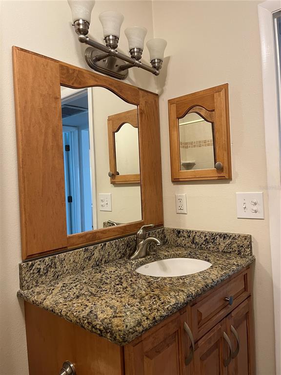 3160 Highlands Boulevard, Unit 3160 Palm Harbor, FL 34684 - Photo 24 of 40 a bathroom with a granite countertop sink and a mirror