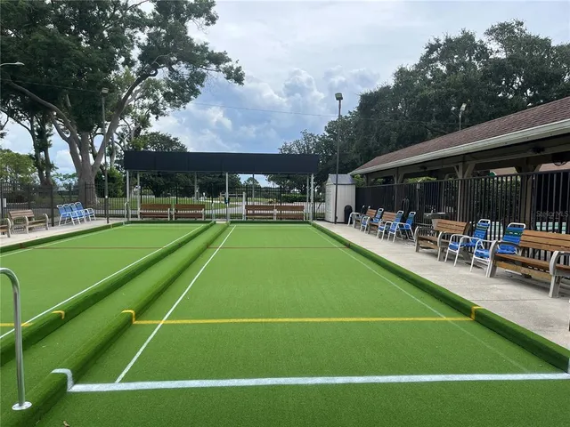 a view of a tennis court with chairs and table