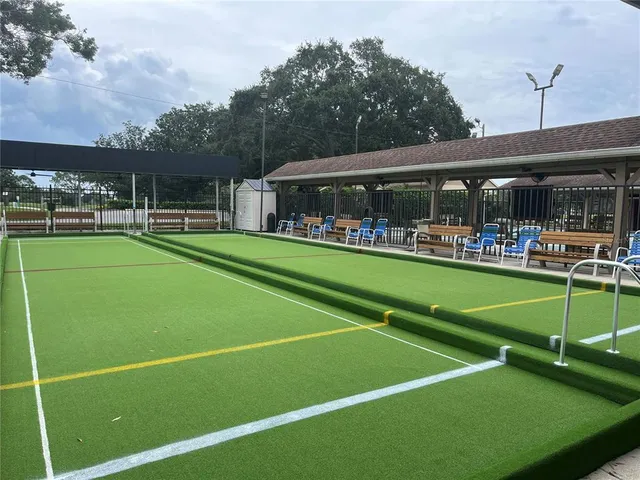 a view of a tennis ground with large trees