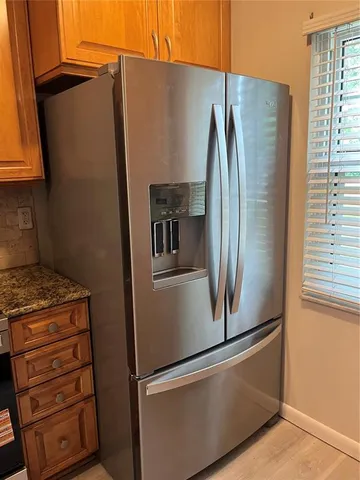 a metallic refrigerator freezer sitting in a kitchen