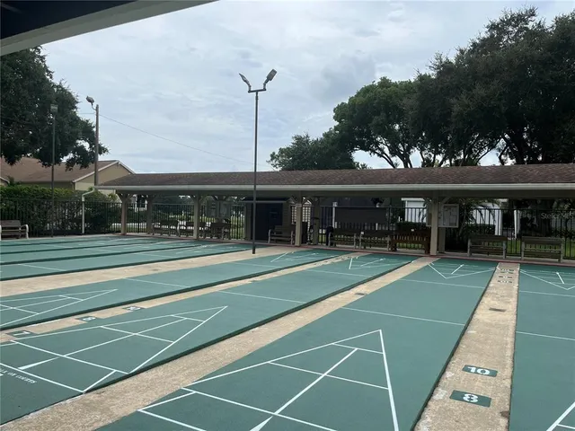 a view of a tennis ground with large trees
