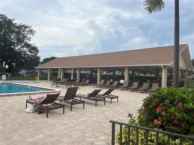 a view of a patio with table and chairs potted plants and palm trees