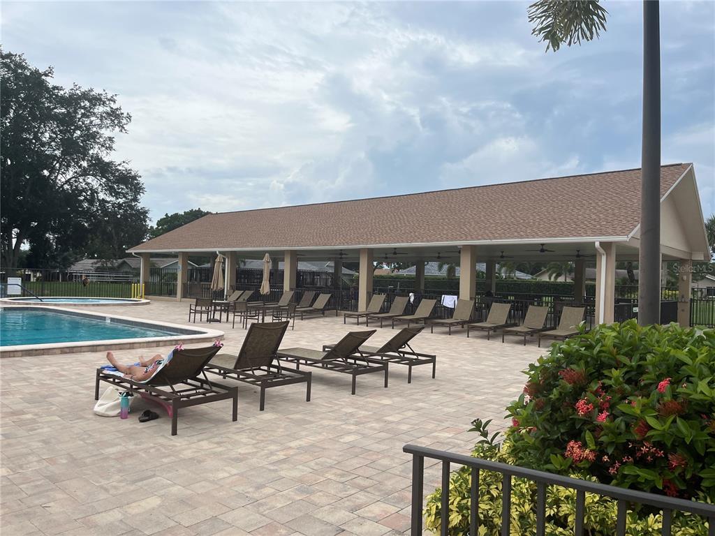 3160 Highlands Boulevard, Unit 3160 Palm Harbor, FL 34684 - Photo 39 of 40 a view of a patio with table and chairs potted plants and palm trees