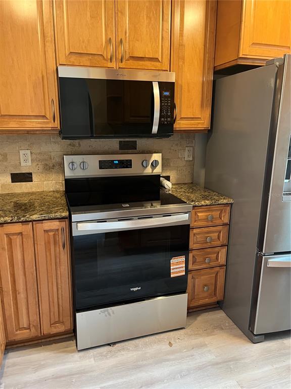 3160 Highlands Boulevard, Unit 3160 Palm Harbor, FL 34684 - Photo 4 of 40 a kitchen with granite countertop cabinets and steel stainless steel appliances