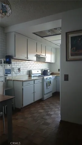 a kitchen with a sink a stove and cabinets