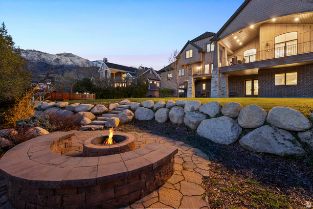 1205 North Elk Rdg Lane, Unit 202 Alpine, UT 84004 - Photo 84 of 88 Expansive backyard featuring a built-in stone fire pit with curved seating, flagstone pathway, and rock retaining walls