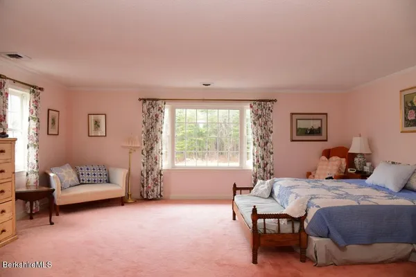 a bedroom with a bed a lamp and a large window