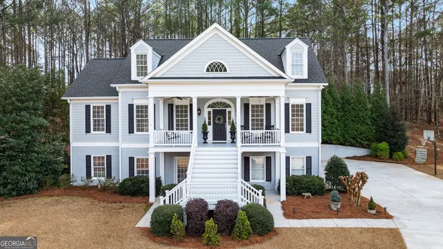 a front view of a house with a yard and trees