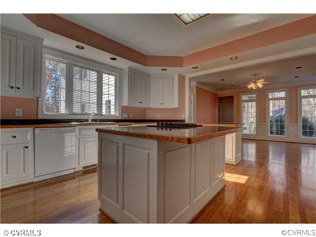 14131 River Road Chesterfield, VA 23838 - Photo 8 of 24 a kitchen with granite countertop a stove a sink wooden floor and cabinets