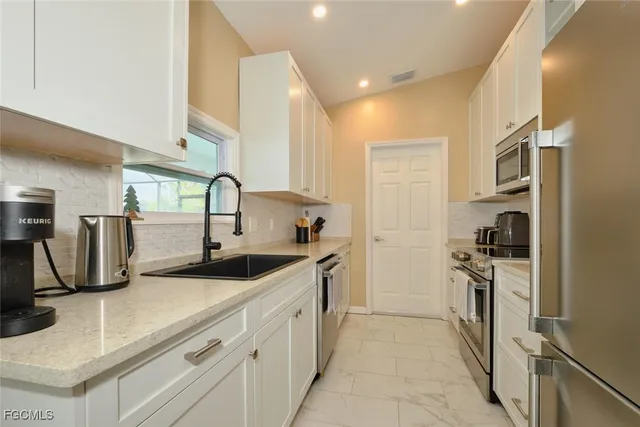 a kitchen with a sink and stainless steel appliances