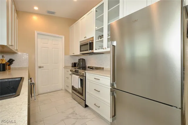 a kitchen with cabinets stainless steel appliances and sink