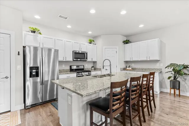 a kitchen with granite countertop a center island stainless steel appliances and cabinets