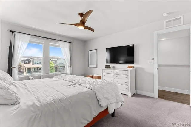 a bedroom with a bed tv and a window