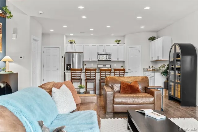 a living room with furniture and a view of kitchen