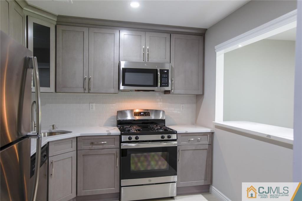 4003 Hana Road Edison, NJ 08817 - Photo 2 of 17 a kitchen with a stove and a microwave